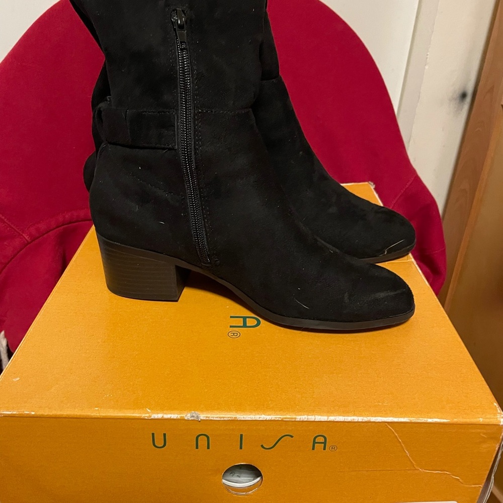 It black sued tall boot a little bit above the knee.